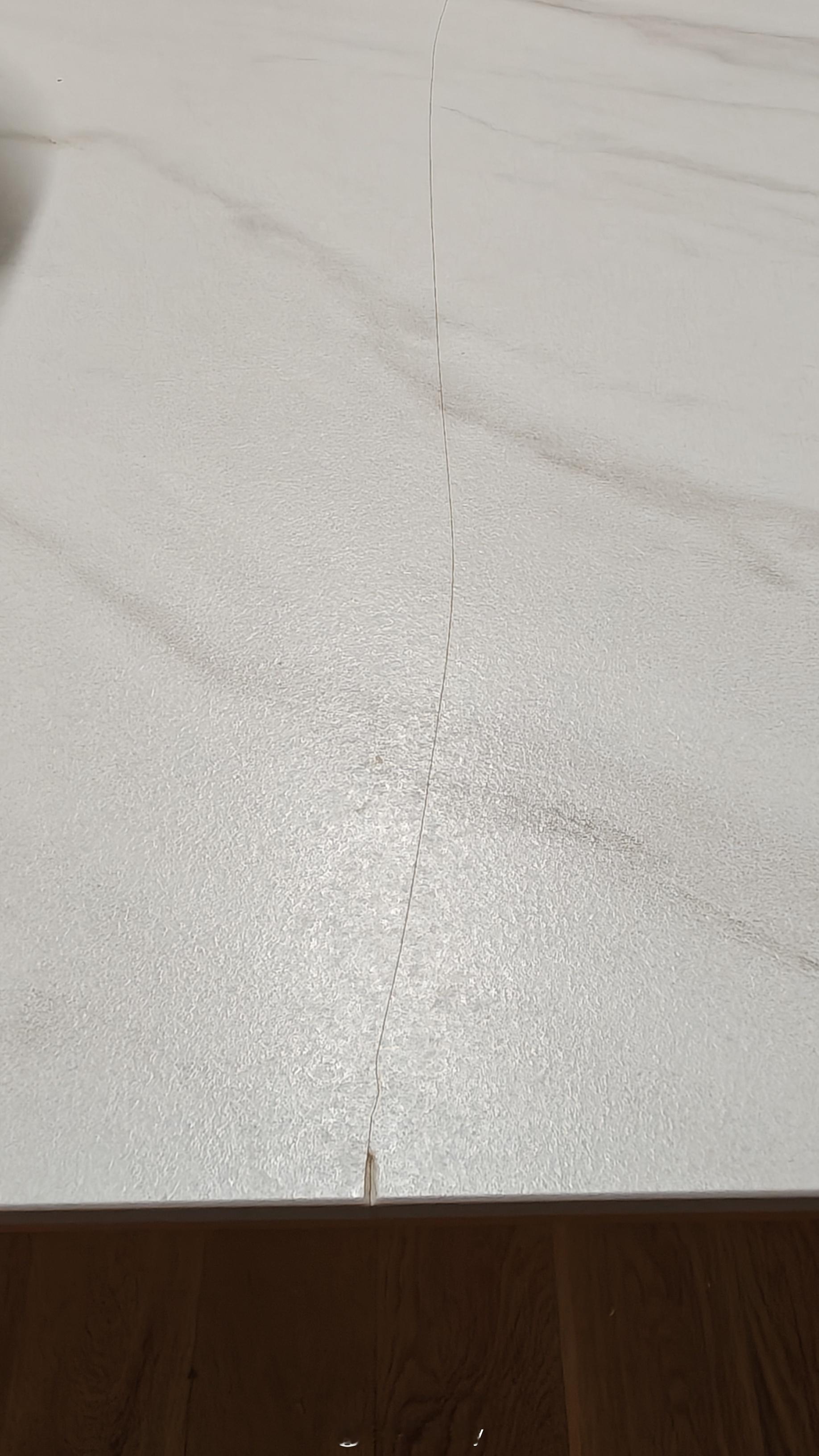 好奇怪，乐歌升降桌这个岩板突然间裂了，裂的这一块直接穿到了对面..印象中也没有磕