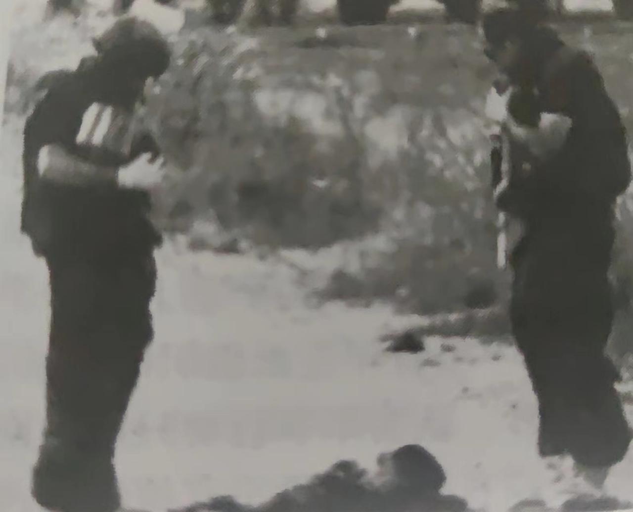 这张照片记录了两名以色列士兵望着脚下“人体炸弹”形成的人体碎片时，无比复杂的神情