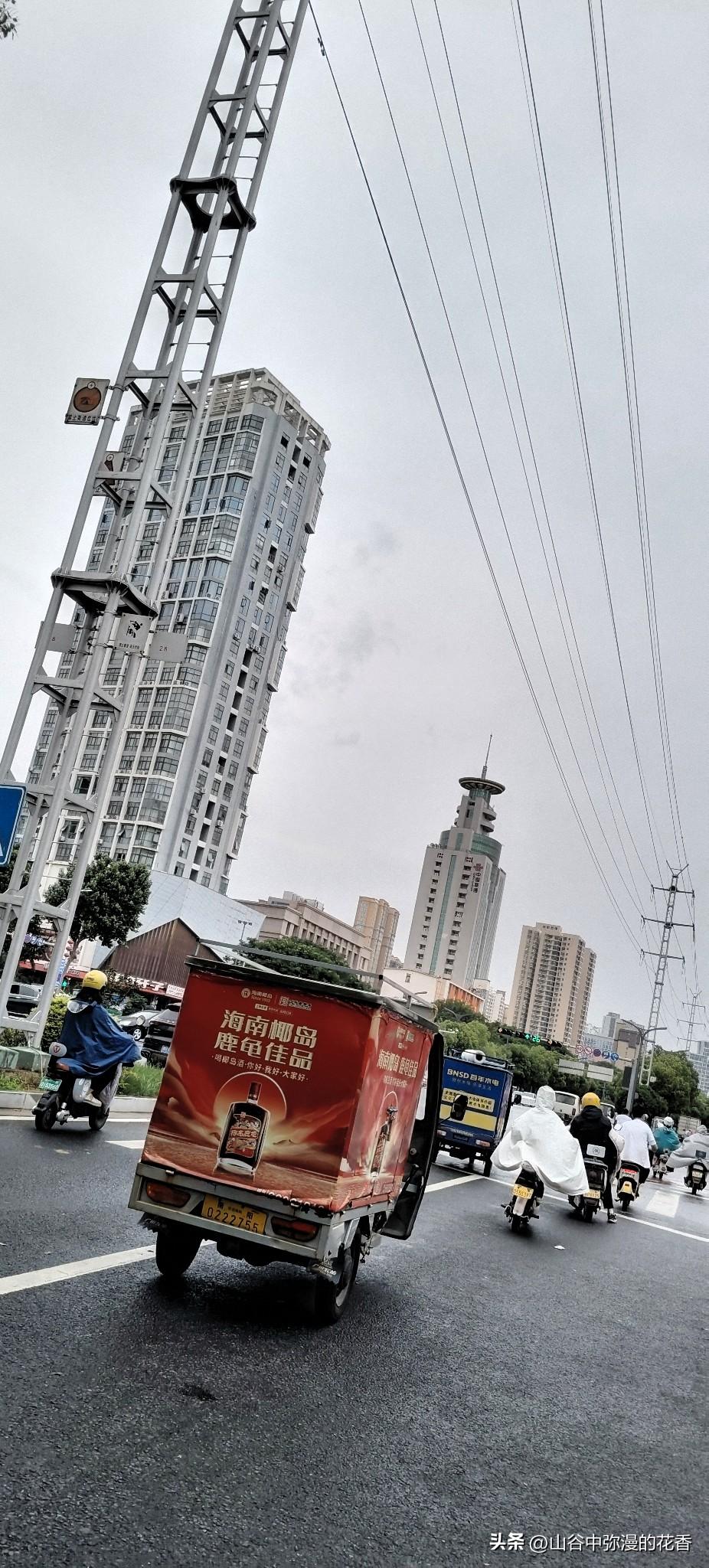 忙碌的街道，快递小哥穿梭其中，现代都市的节奏感扑面而来。城市街角随手拍
