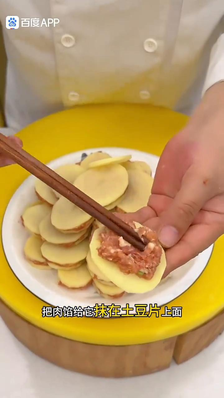 炸土豆盒。
大家注意看，把肉馅抹在土豆片上面，然后在上面盖个土豆片捏一捏，做好以