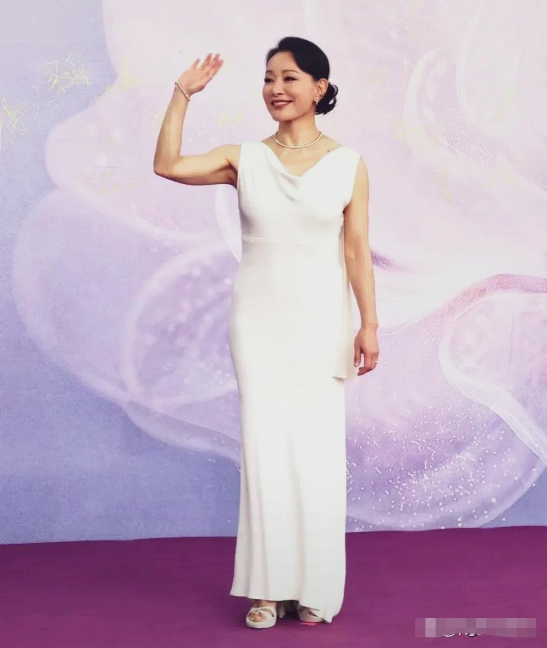 陈冲亮相百花奖红毯一身无袖白色鱼尾长款礼服，黑发盘成低发髻，干净利落。
行走红毯