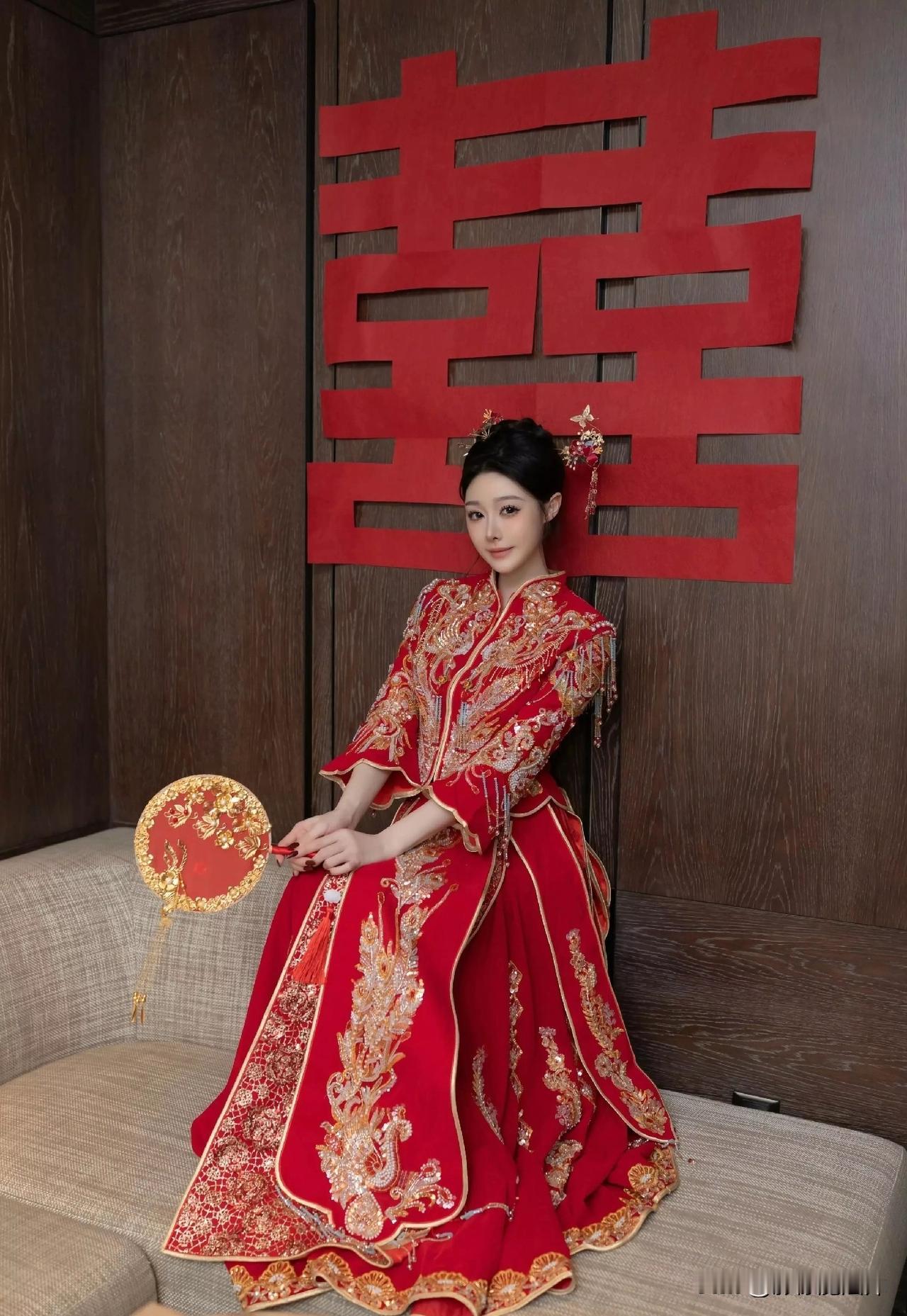 镜头里，正红秀禾服艳得抓眼，金凤凰在衣上“飞”着，珍珠流苏随动作轻晃，新娘手里的