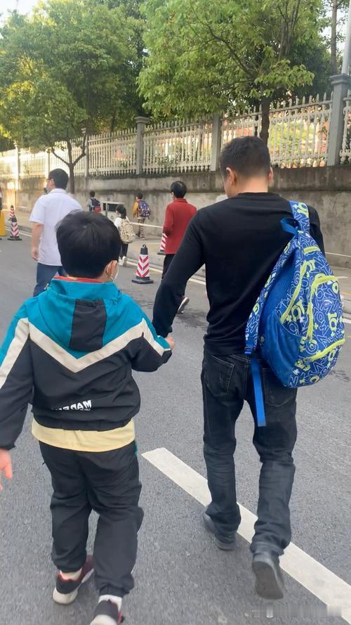 “太感动了！”夫妻俩去幼儿园接三岁儿子放学，儿子见到爸妈后，立刻把书包icon放