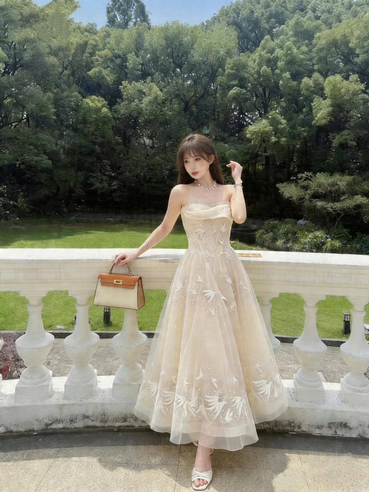 一袭浅杏抹胸蓬裙，缀满灵动刺绣与细碎闪钻，
轻盈裙摆随风轻扬，像坠入凡间的林间公