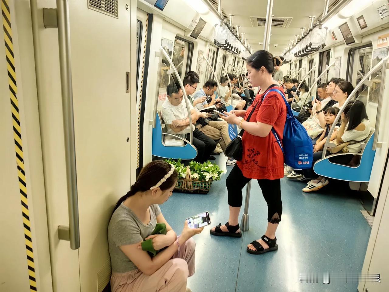 谁是这一篮子栀子花的主人？在成都地铁一号线列车上，刚进车厢，看到旁边车厢地上放了