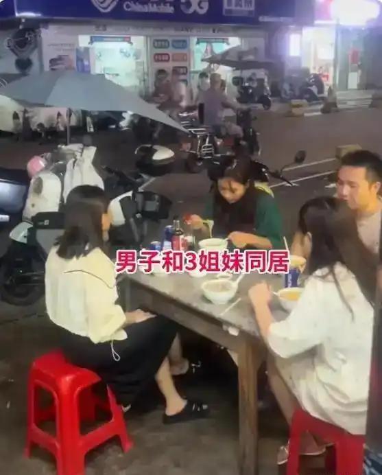 广东夜市这一幕，最近在网上传开了。一张小方桌，四条凳子，一名男子身边坐着三位容貌