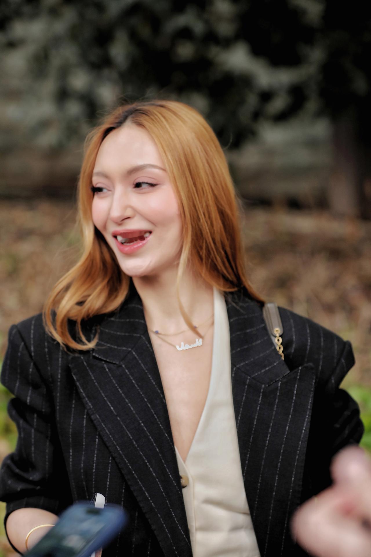 《光影里的优雅》
她以一身利落穿搭，演绎出女性独有的优雅与力量。焦糖色波浪卷发蓬