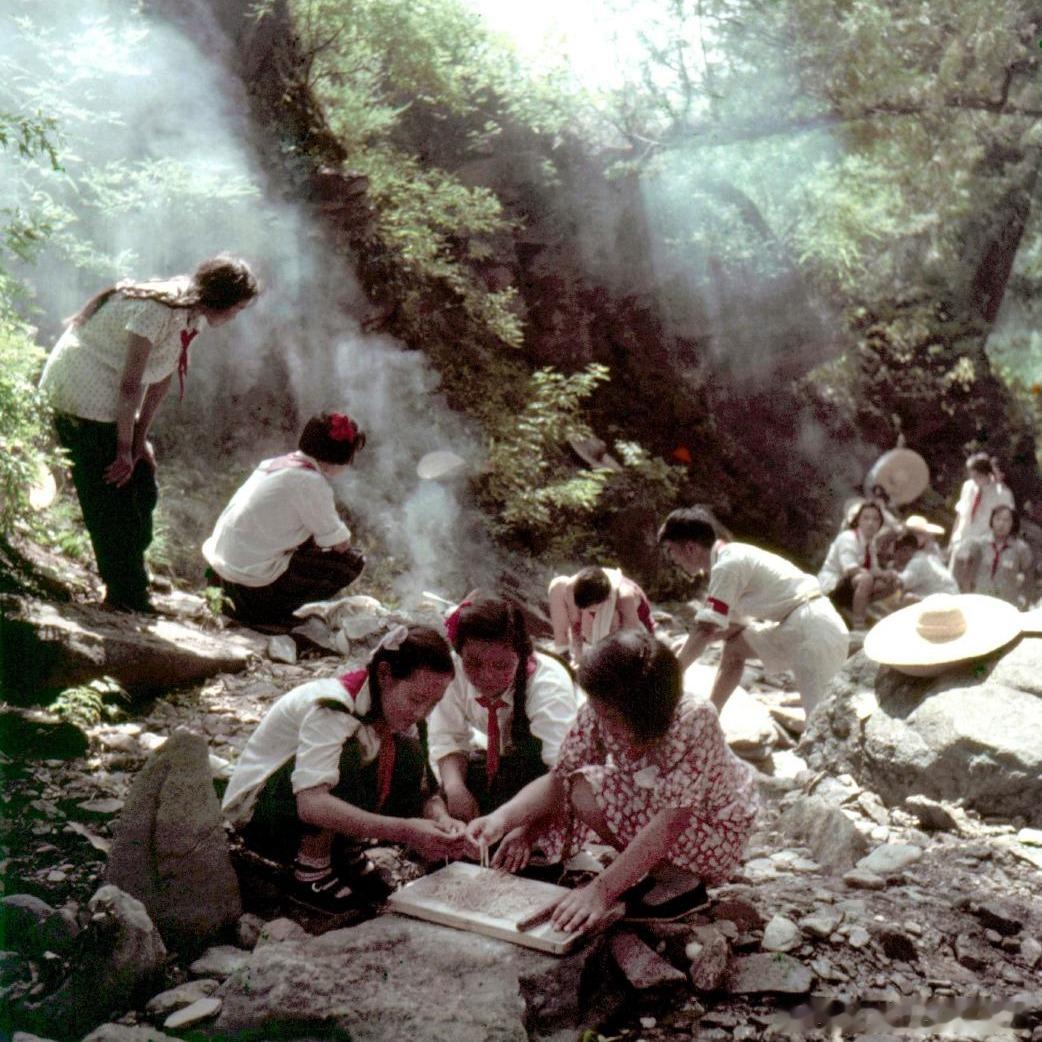 1956，北京郊外山林，夏令营的孩子们利用石板充当案板，野外动手擀制面条。人民画