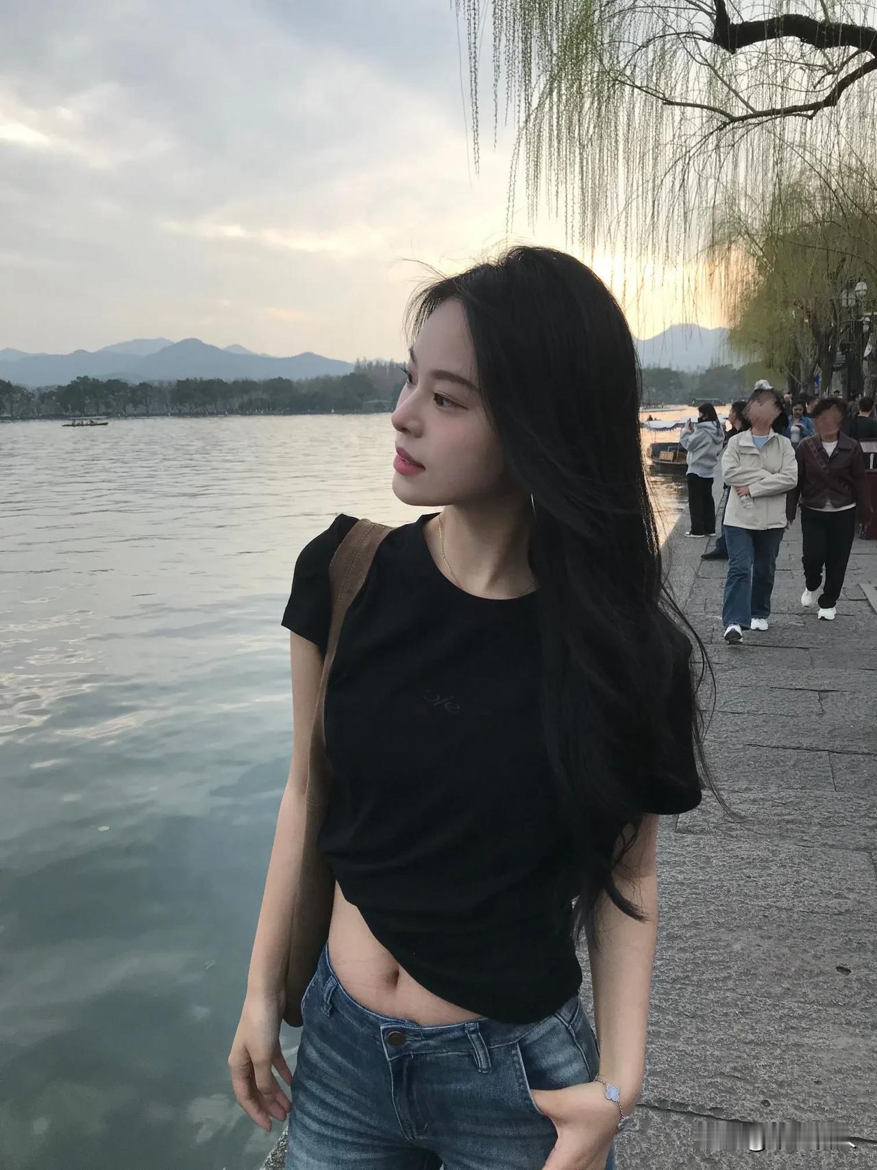 一个女孩站在湖边看风景。