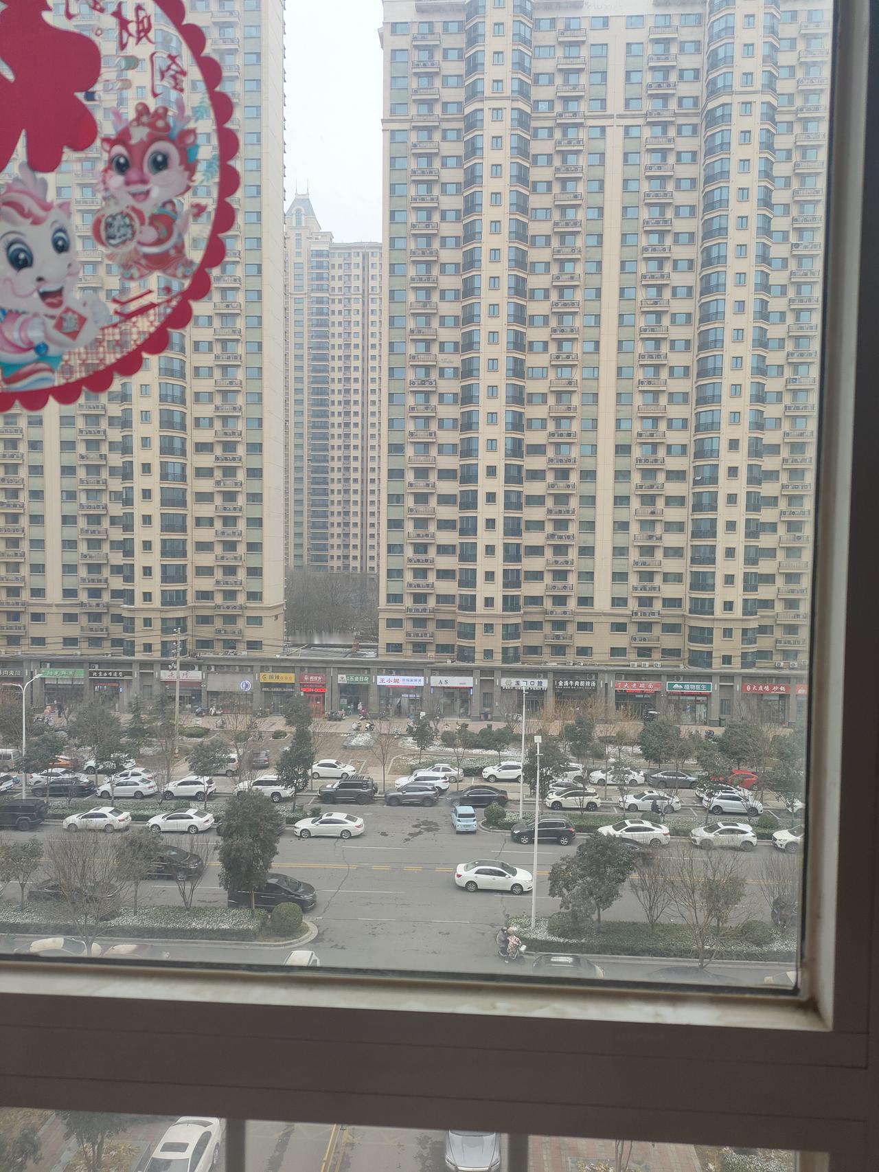 站在窗边往外看，外面很冷，地上还飘着点残雪，高楼底下的车都缩着似的跑。我屋里可就
