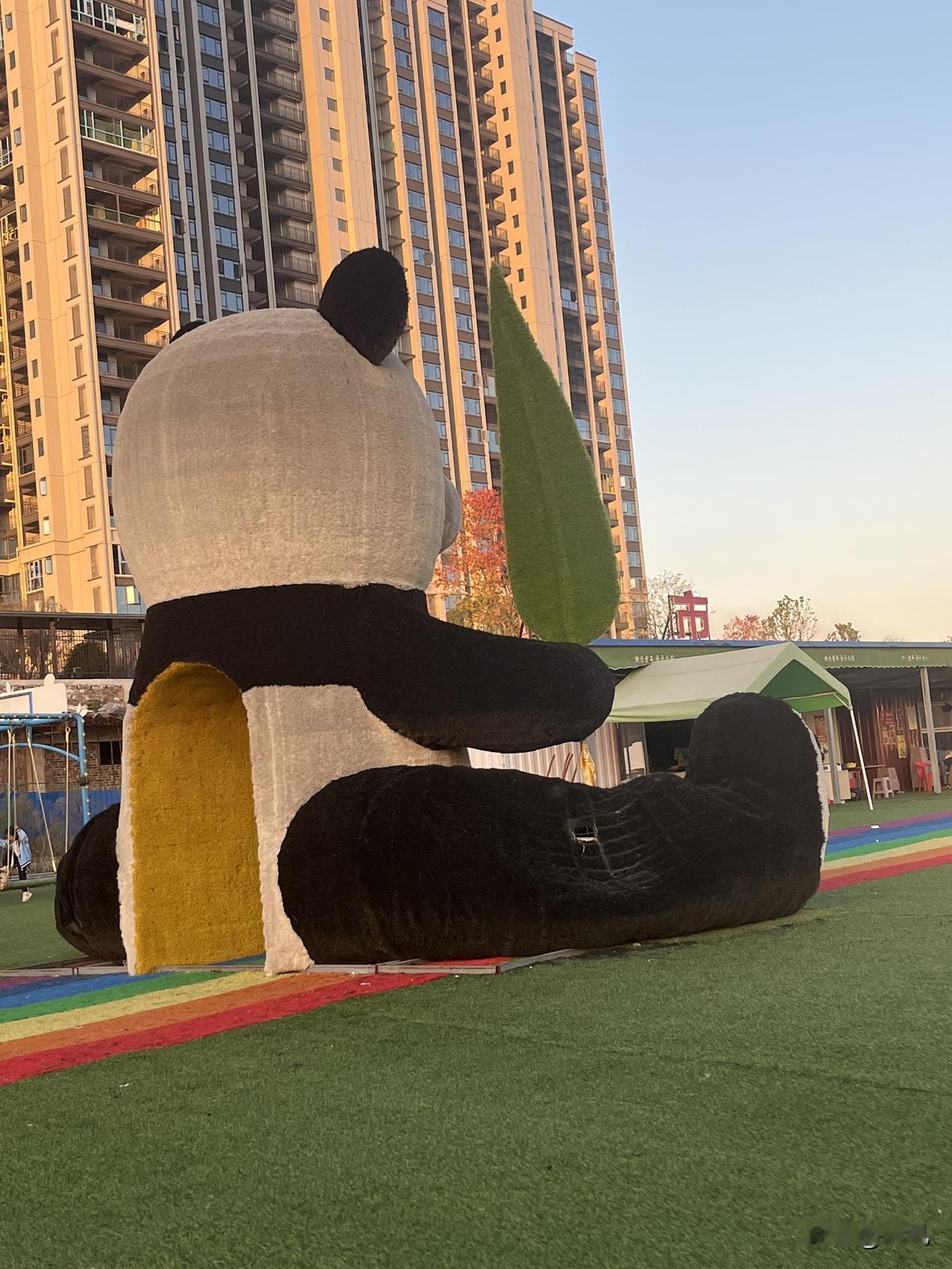 傍晚路过小区楼下的小广场，一眼就被这只“巨型熊猫”勾走了脚步——这圆滚滚的背影也