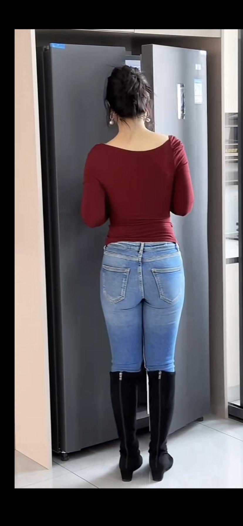 这姑娘正站在冰箱前找东西呢。