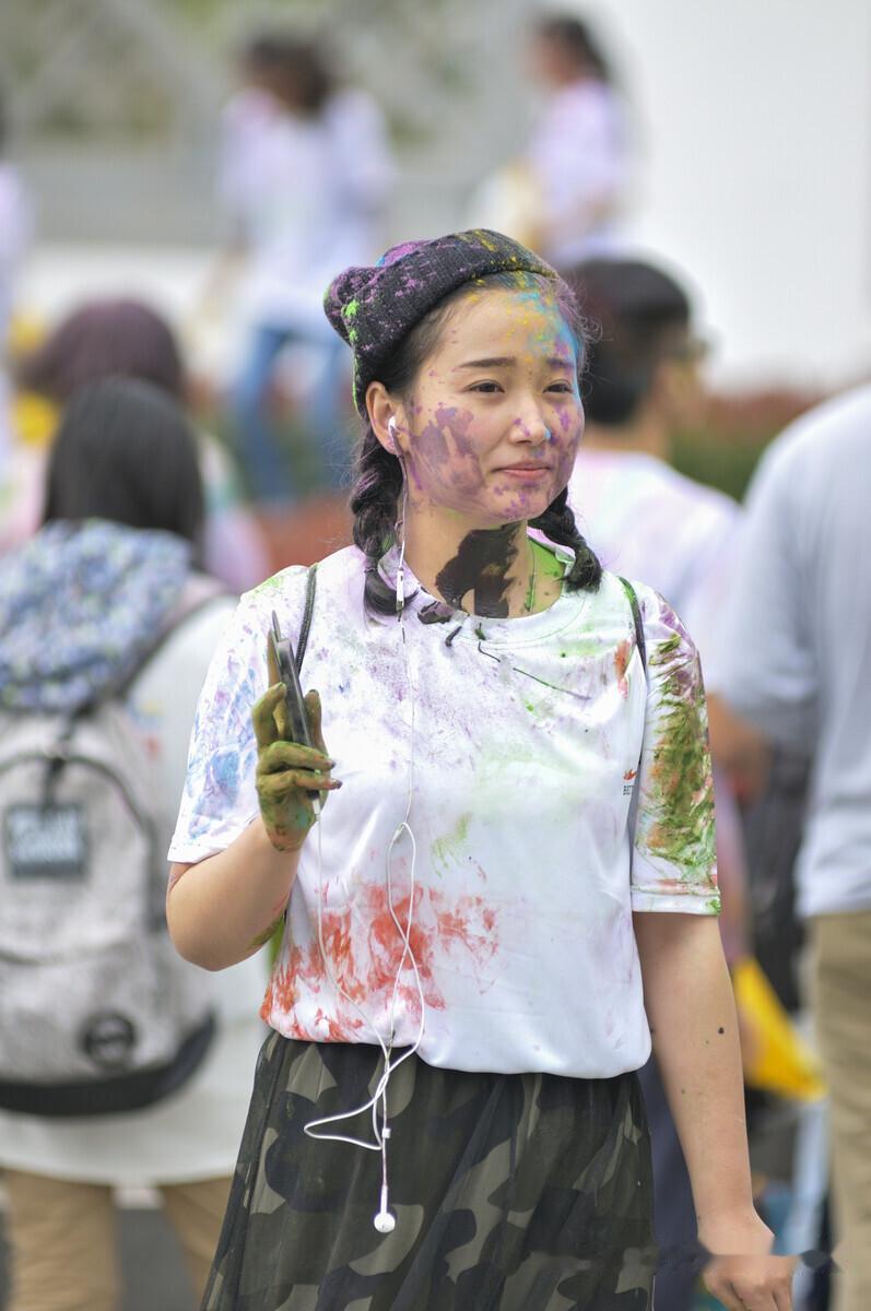 这是一场在苏州石湖举办的万人彩虹跑活动现场拍摄的一张人物照片。一个漂亮的女生满身