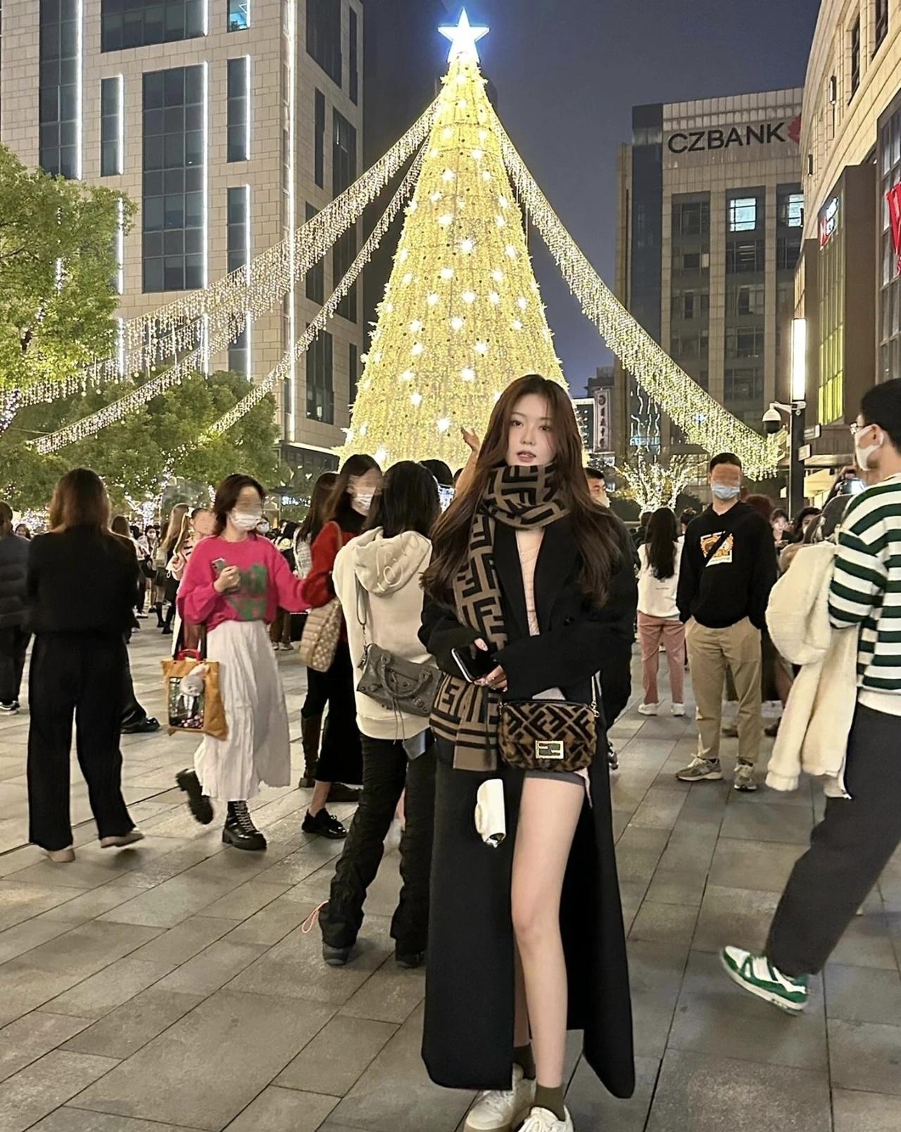 夜晚的街头，灯火璀璨的圣诞树，人群熙攘，洋溢着节日的欢乐与温馨。