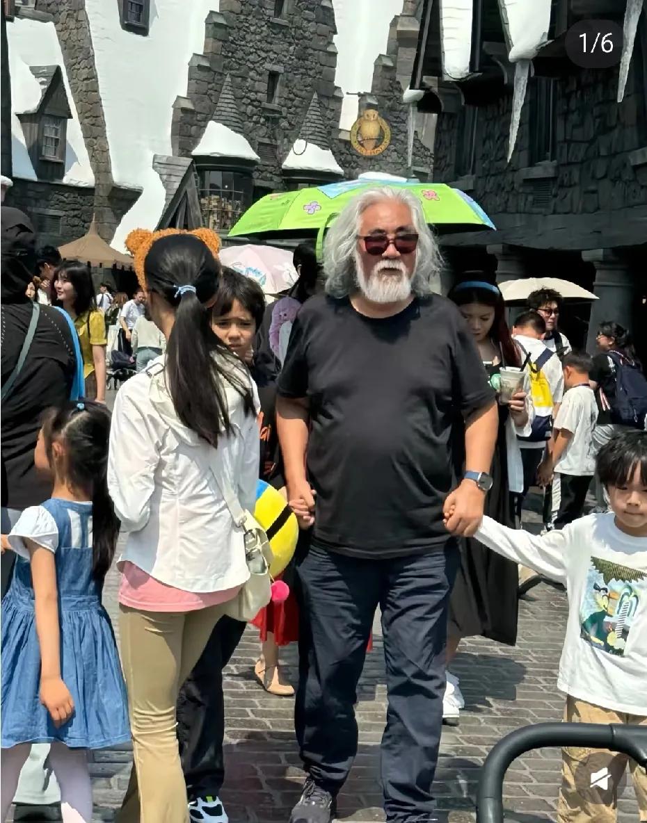 74岁张纪中双手牵俩娃游北京环球影城，真是一位好爸爸，老师的气血也很旺，一看就不