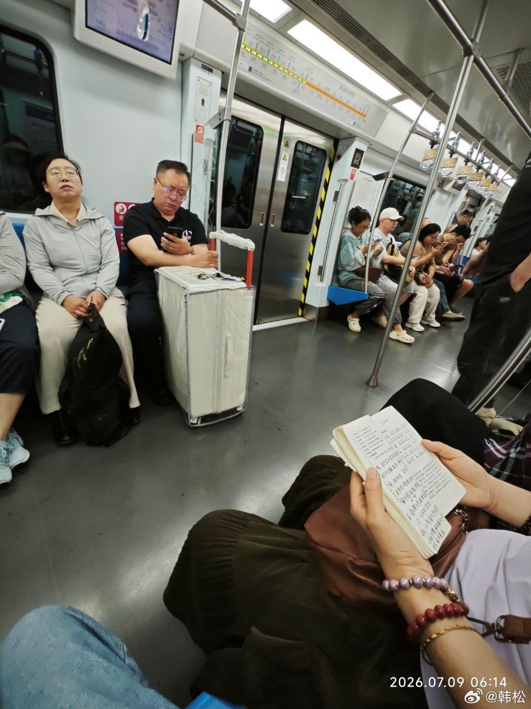 清晨的地铁是菩提树，女乘客在专心读佛经。 