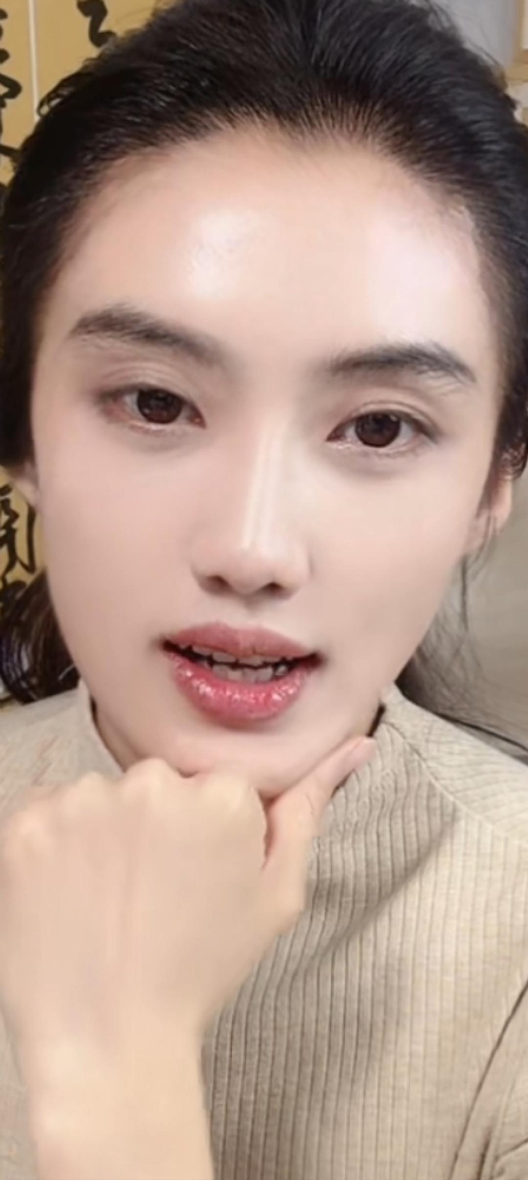 这姑娘在自拍，手托着下巴。
