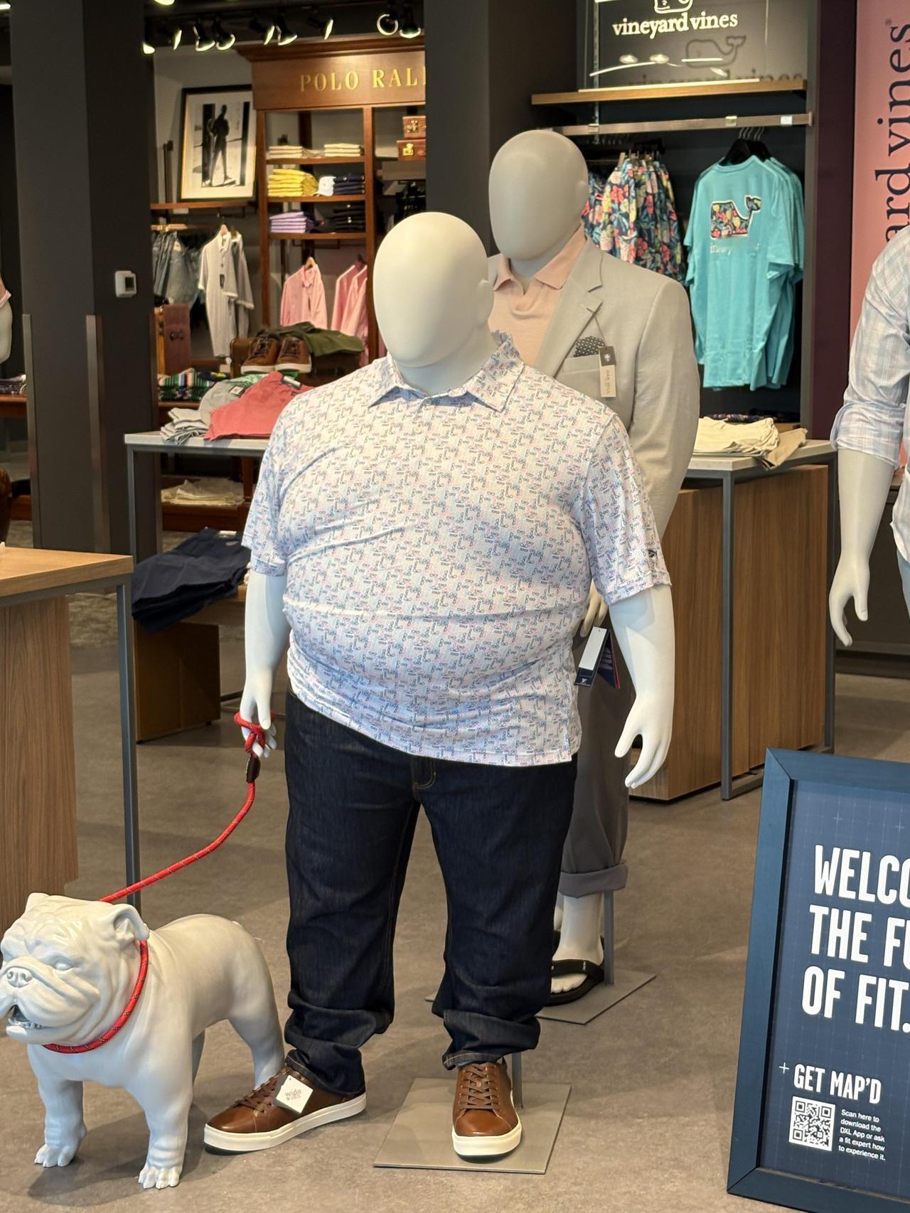 这是大码男装店用模特人偶展示衣服的真实效果——一个身材高大的男性模特穿着紧绷的T