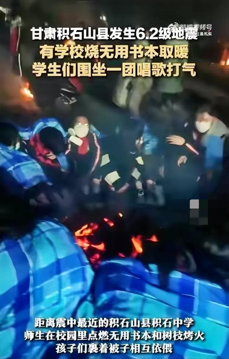 天寒地冻，甘肃受地震灾害的中小学生，用废旧的书本燃起篝火取暖。有人认为书是精神财