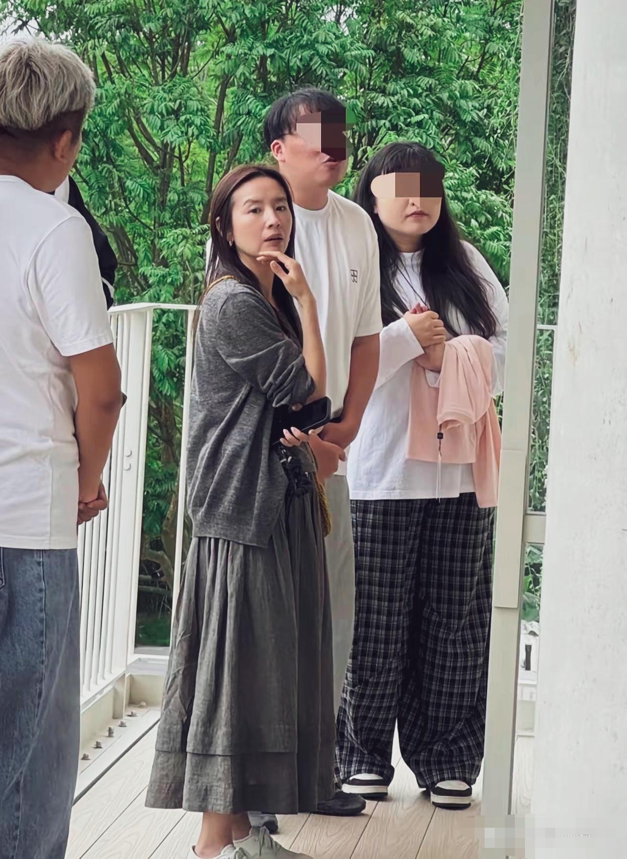 董洁在广州看房的路人抓拍，个子不高，一身灰调松弛穿搭，脚踩小白鞋，长发自然散落。