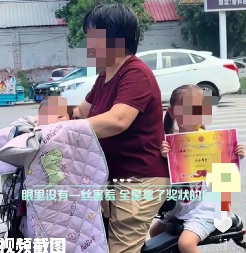 有一位女子去学校带两孩子回家。

其中一名小女孩因在学校表现出色，获得了学校颁发