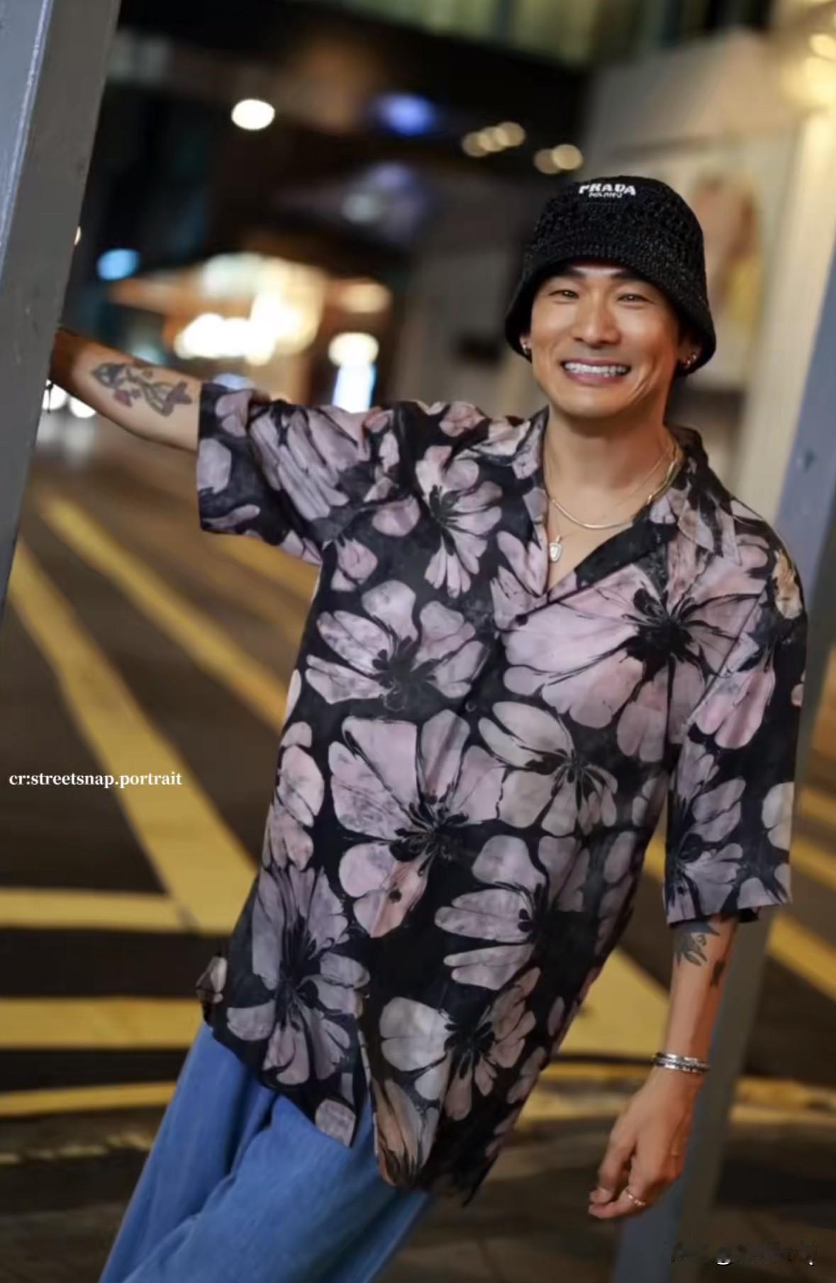 63岁的杜德伟被邀约街拍，宽松花衬衫搭配宽松拖地牛仔裤，脚穿罗马凉鞋，看着是真潮