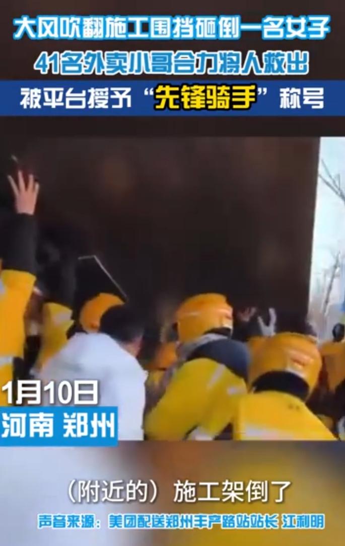 风把路边的施工围挡掀翻，一名过路女子被压在底下，街头的冷空气仿佛在那一刻凝固。