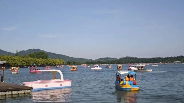 五一小长假首日，玄武湖的湖面上早早就飘满了各式游船，明黄的、天蓝的、卡通造型的脚