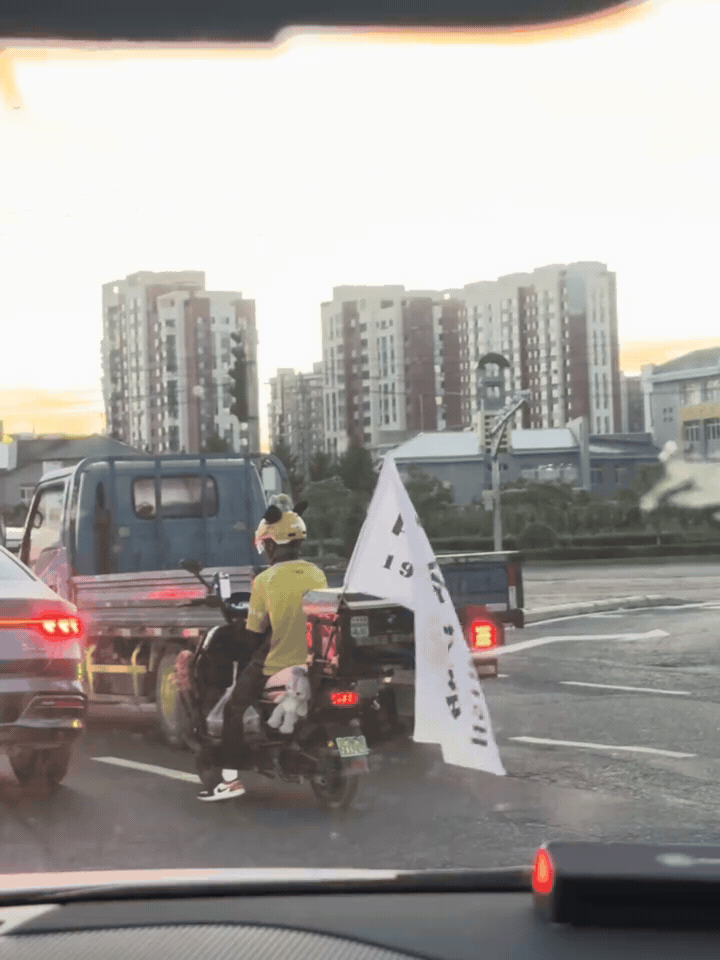 一面旗帜在路上，普通人的爱国情怀

车流之中，一名外卖骑手车尾旗帜格外显眼。

