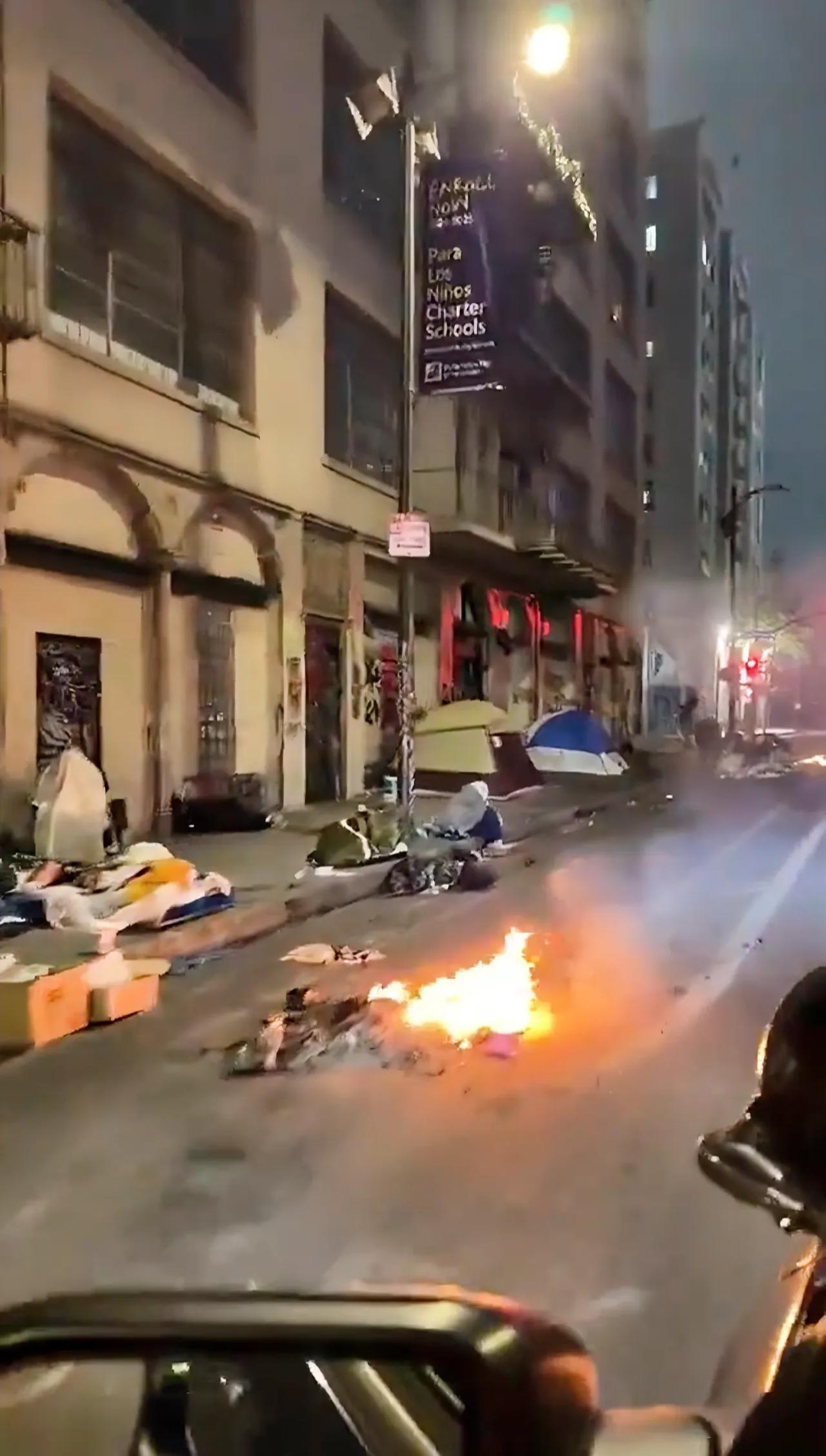 这是美国洛杉矶的一个角落，无家可归者中条件好点的搭个帐篷，条件一般的就只能露宿街