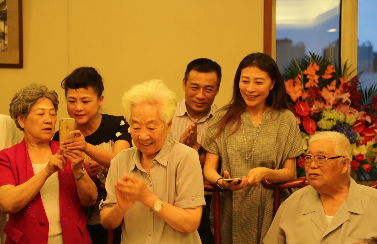 这张6人合照，我认出了身穿红半袖衫、手持苹果手机的艺术家陶玉玲与满头银发、气色盈
