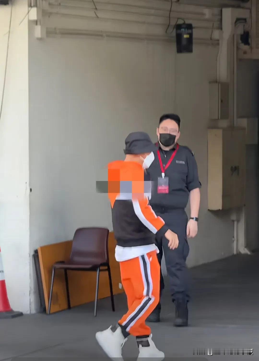 著名演员张卫健抵达香港红磡体育馆，头戴黑色帽子，嘴巴上戴着白色口罩，只露出眼睛，