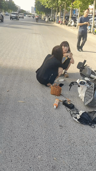 两个年轻女孩同骑一辆电动车在马路上突然发生车祸。
她们骑的电动车被一辆汽车撞倒了