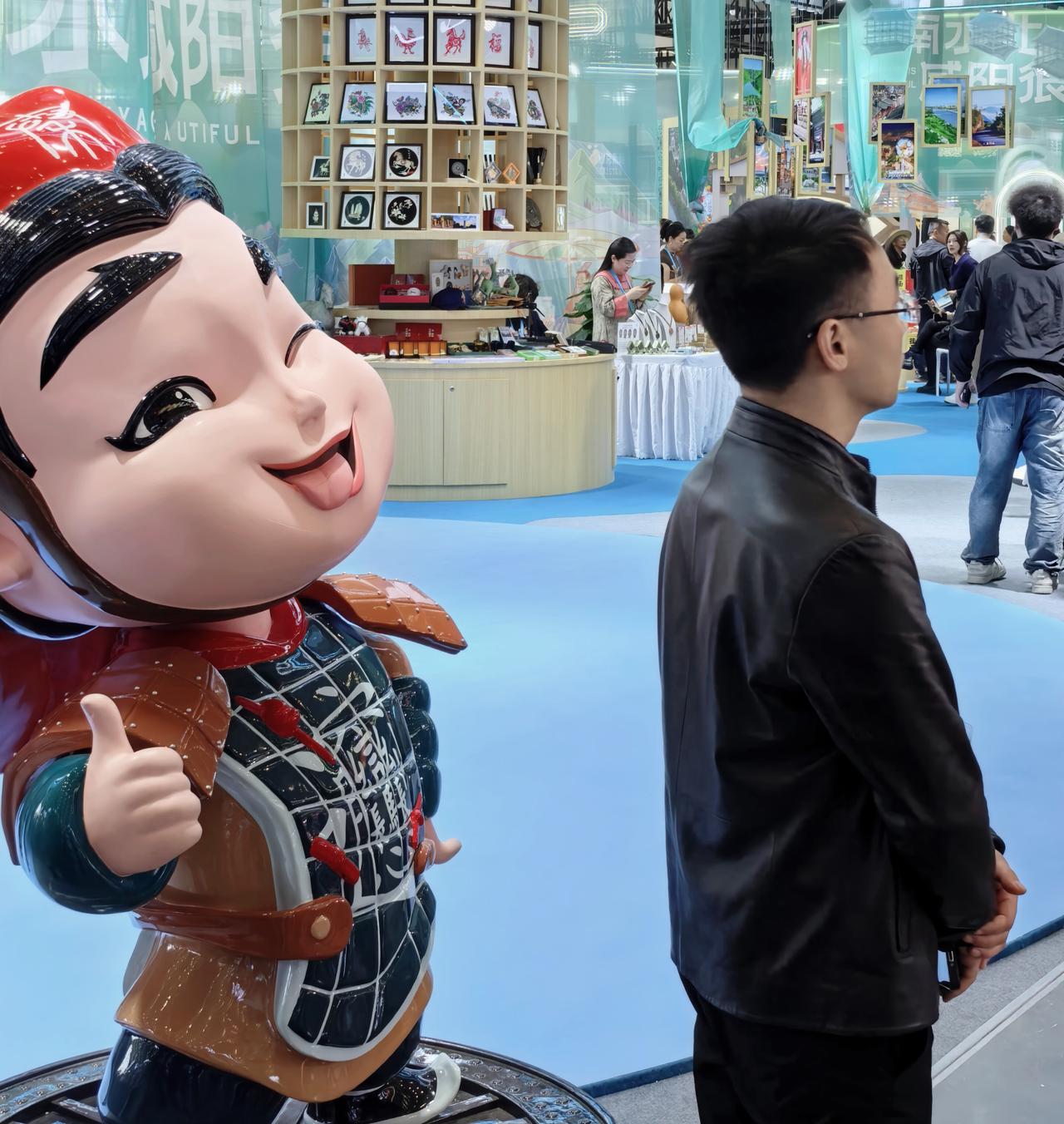 卡通俑咧嘴笑，其状憨态可掬，游人驻足，抬手轻轻击掌，好像古今悄悄对话。