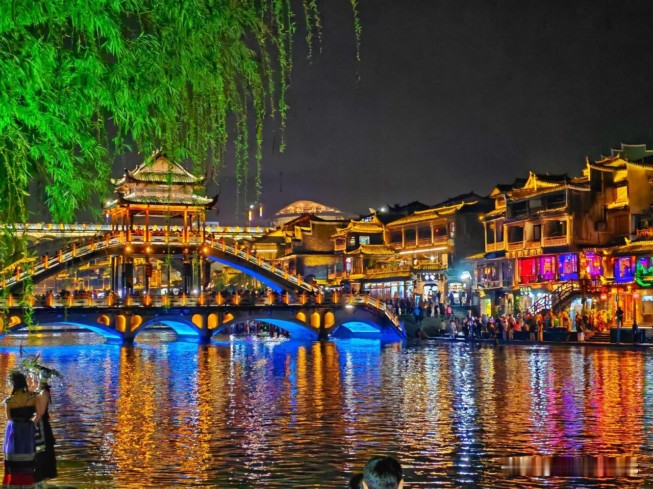 到凤凰古城时，天正飘着雨，撑了伞，沿着江边的石板路慢慢地走。路是湿的，青幽幽地泛