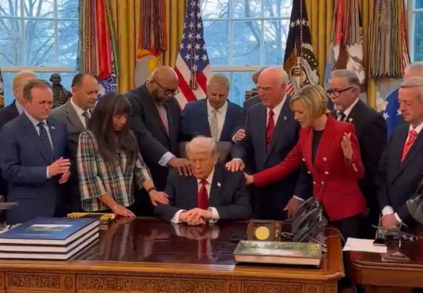 美国白宫里最近上演了这么一出怪事儿：特朗普身边围着二十多个牧师，手搭手念念有词，