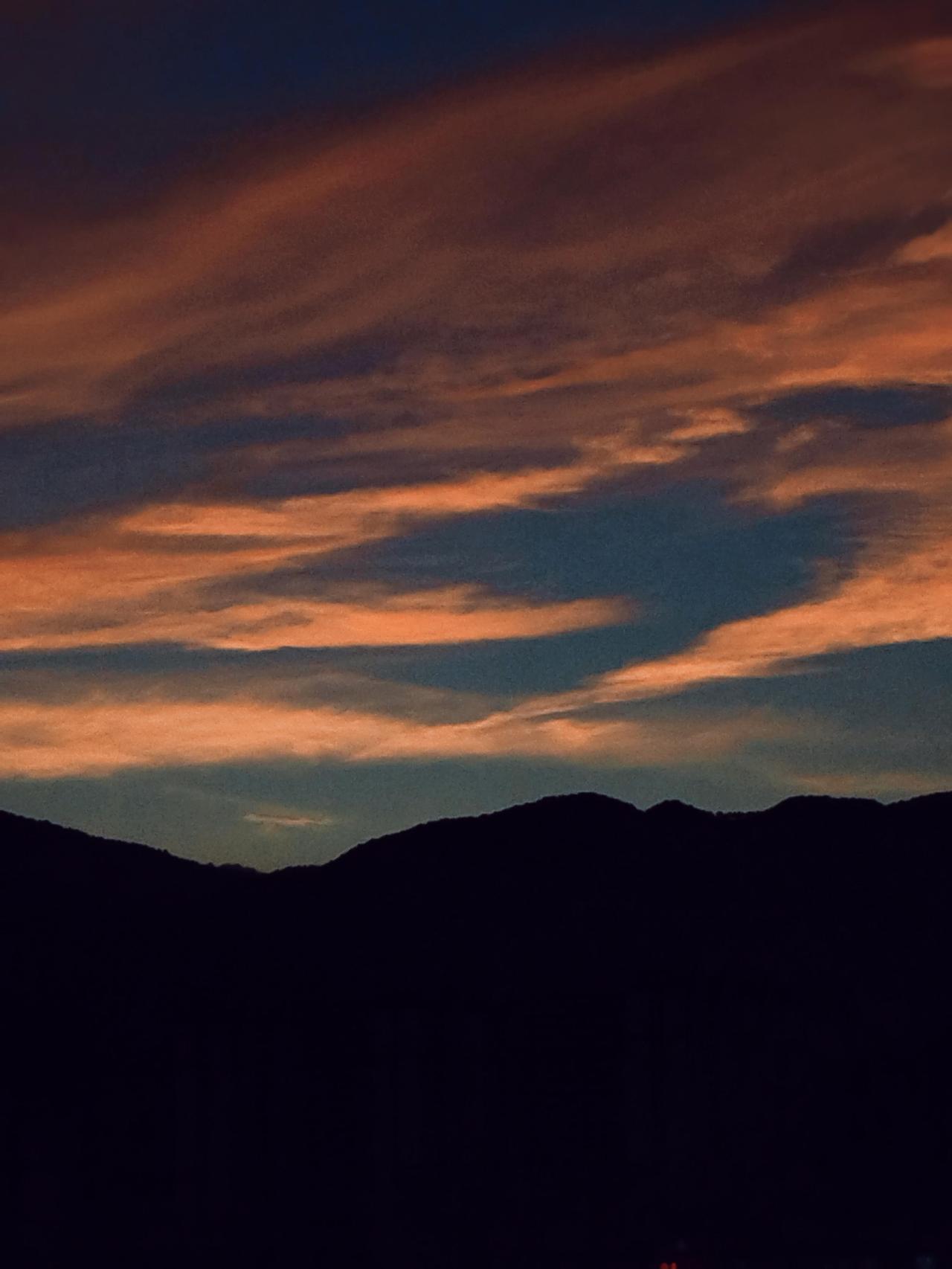 夕阳西下，云霞映山，静谧而美丽。