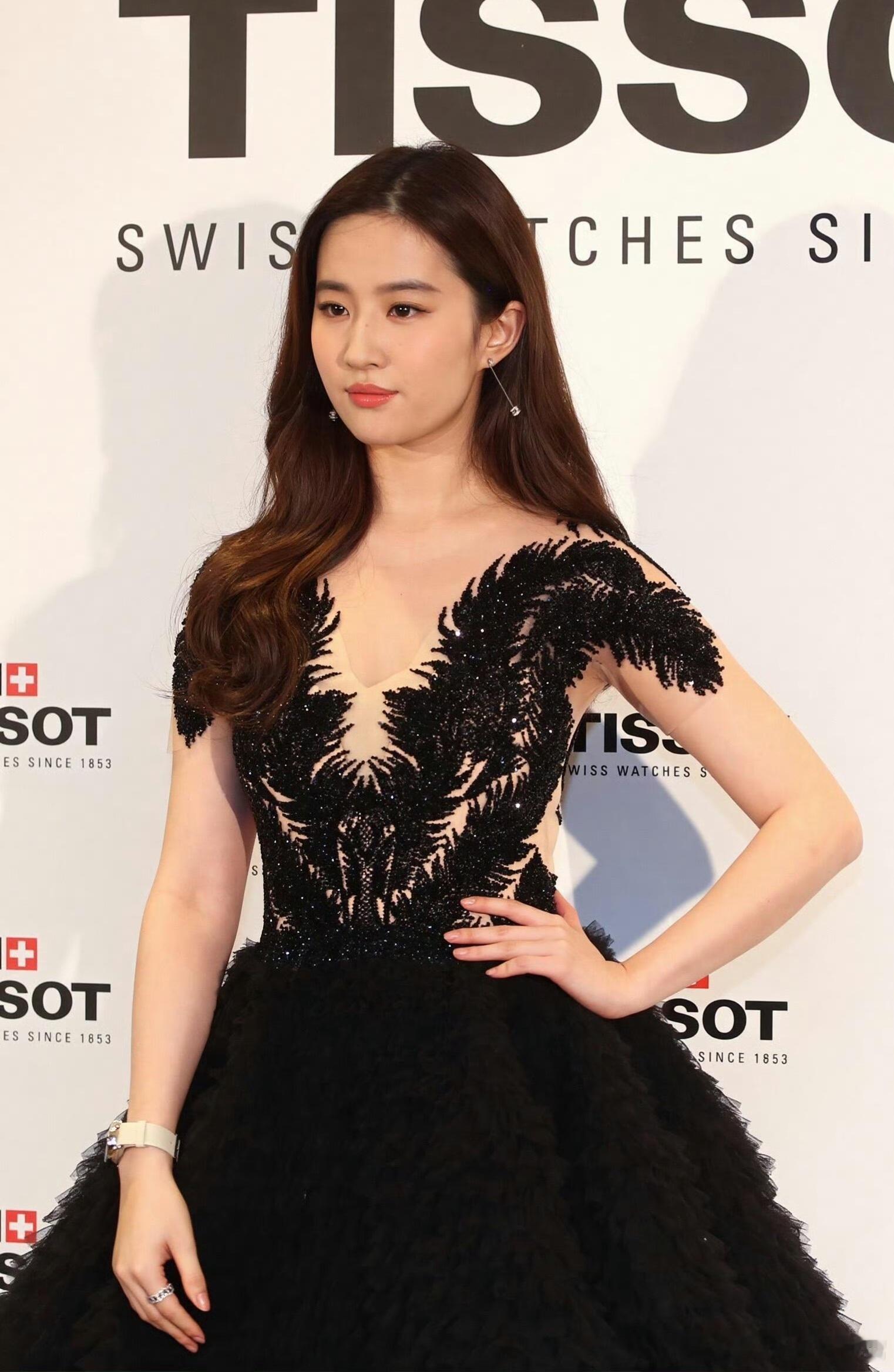 刘亦菲此次的穿搭堪称红毯美学典范，黑羽刺绣蓬蓬礼服上半身裸色网纱打底，立体闪钻绣