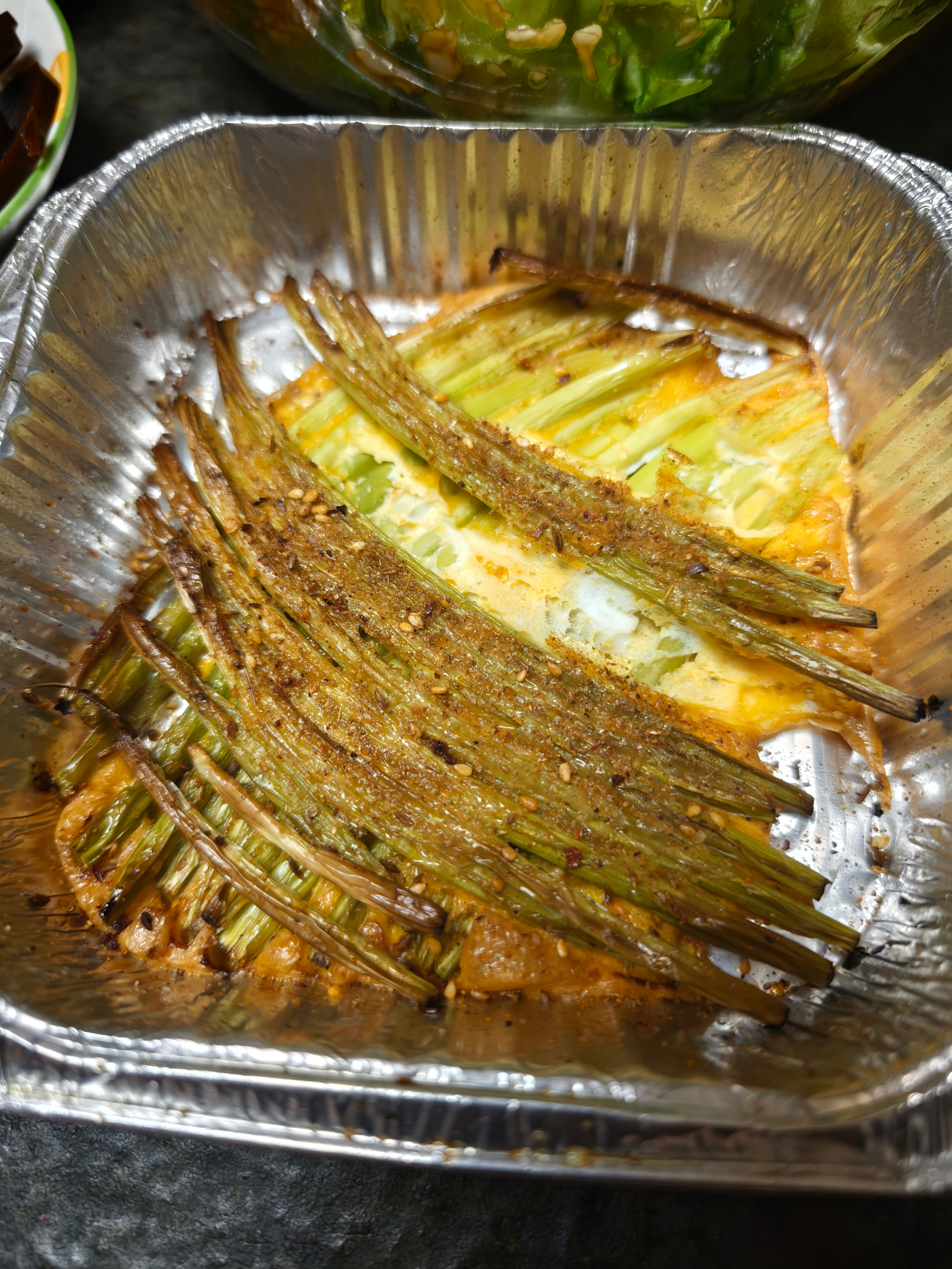 烤蒜薹常规吃法，吃腻了大家可以试一试，蒜薹切好，铺到锡纸盘中两层，倒入鸡蛋液空气