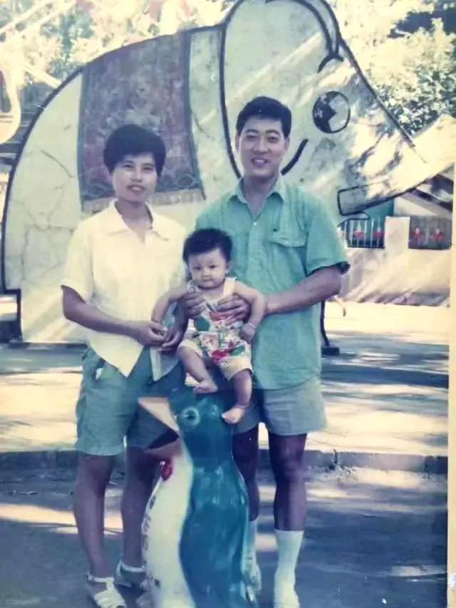 这张拍摄于上世纪九十年代的家庭合照，一眼看上去就是普通幸福的一家三口，带着小宝贝