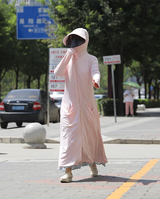 女子穿长款防晒衣骑电动车暗藏风险，因衣服卷进车轱辘，摔倒致多处擦伤，牙也磕破了，