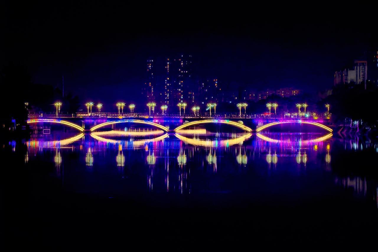 夜幕垂落文井江，晚风漫过崇州城｜廊桥卧波，灯火沿水面铺展开来，粼粼波光接住整座城