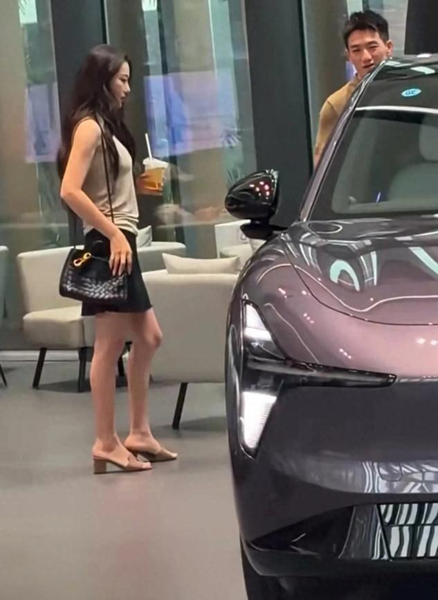 张馨予背4万的包看15万的车，何捷在付款。广州小鹏店里，何捷盯着配置表算续航，她