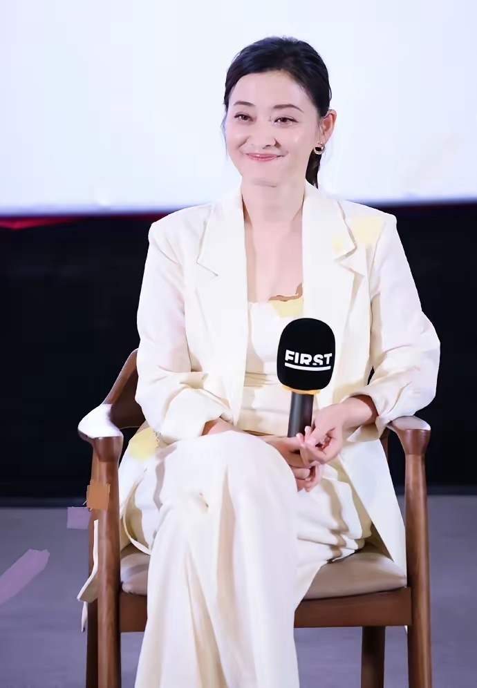 梅婷白色的西装搭配白色裤子，脚踩黑色的鱼嘴高跟鞋，看起来有种神采奕奕的感觉，不得