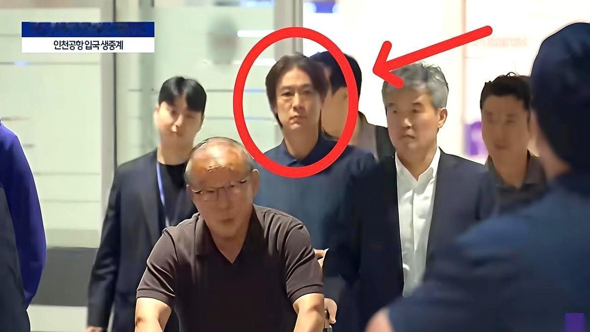 那个被围在中间、面无表情的男人，就是韩国队主帅，洪明甫。
他特意选了半夜的航班，