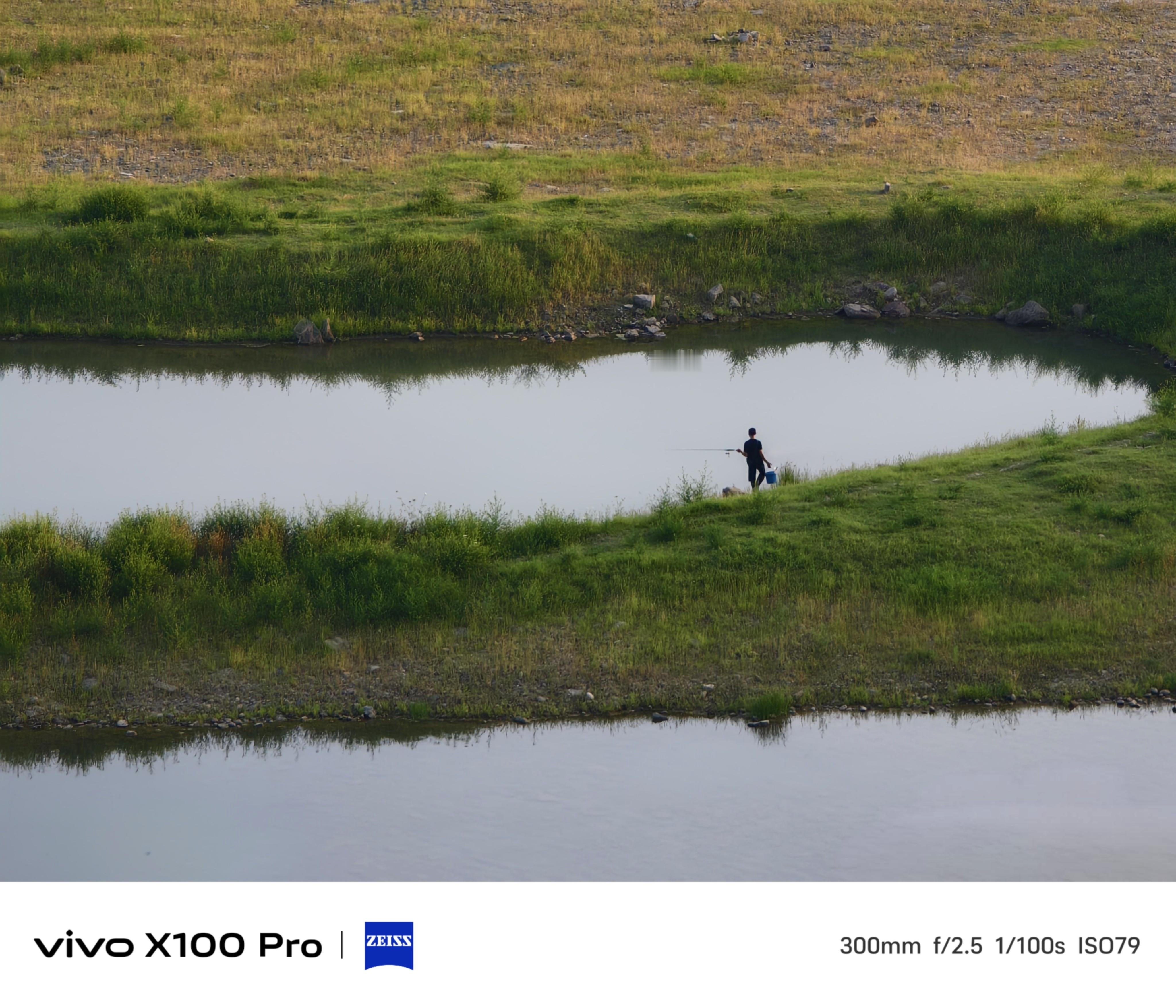 静谧垂钓时光在宁静的湖边，一位垂钓者独享自然的馈赠。静谧的水面映衬着绿色的草地，