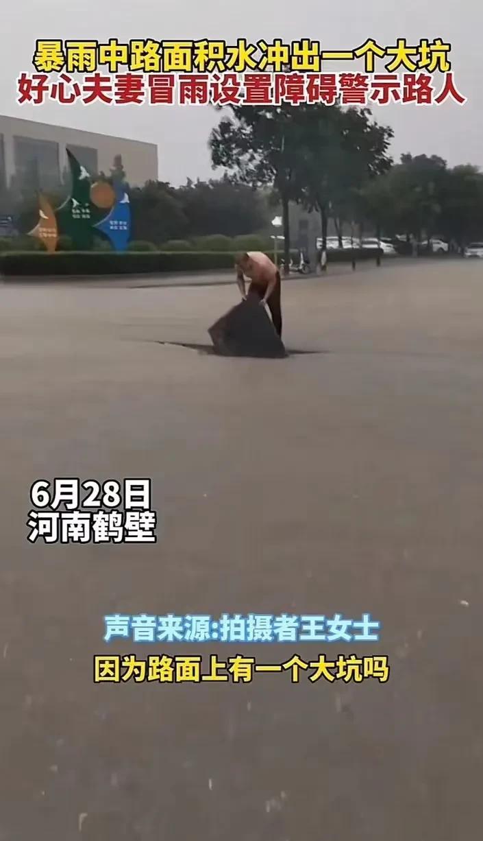 “好人难做啊！”河南鹤壁，雨水覆盖路面大坑，好心夫妇担心路人掉入坑里，用路边的共
