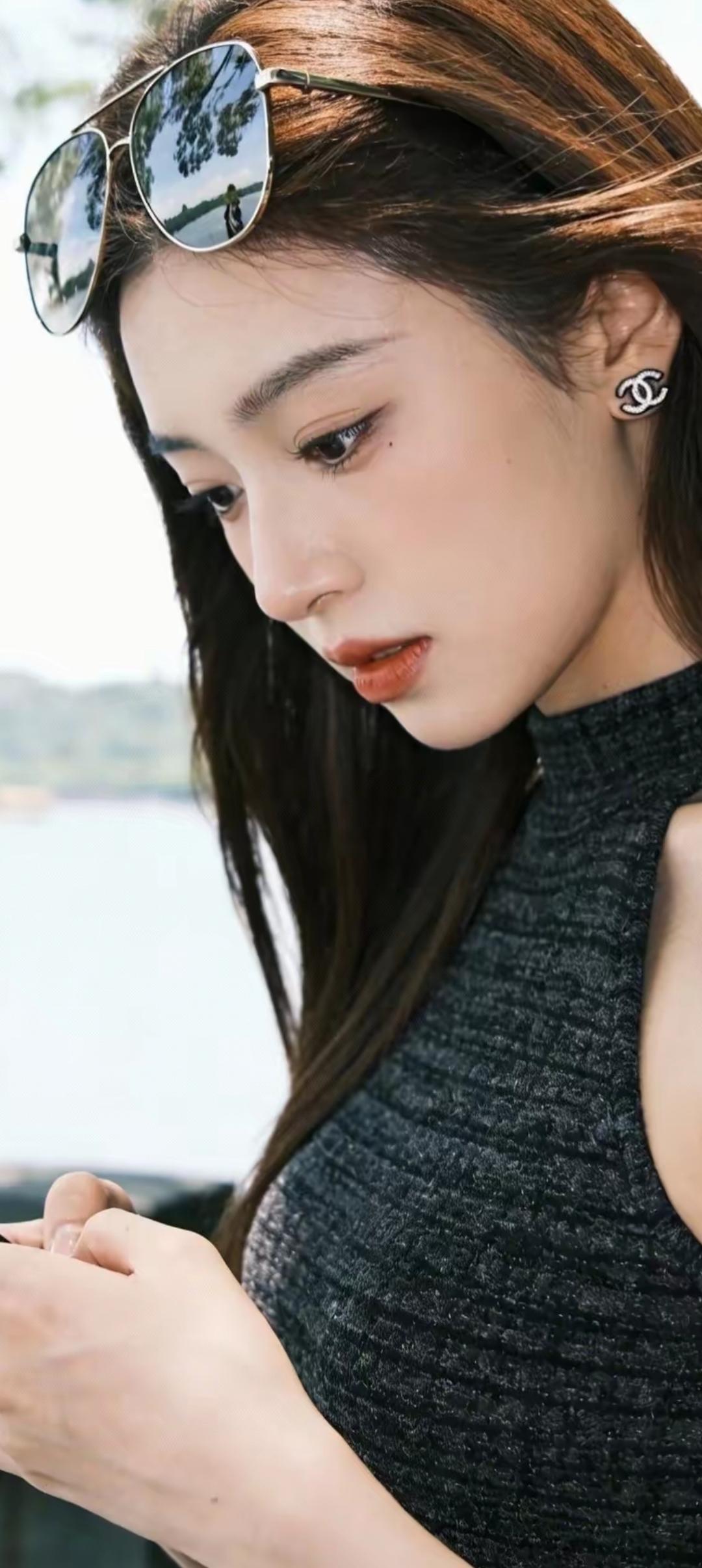 阳光下的时尚少女，墨镜与耳环的完美搭配，尽显优雅与自信。