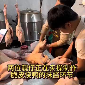 两位靓仔正在实操制作脆皮烧鸭的抹酱环节。