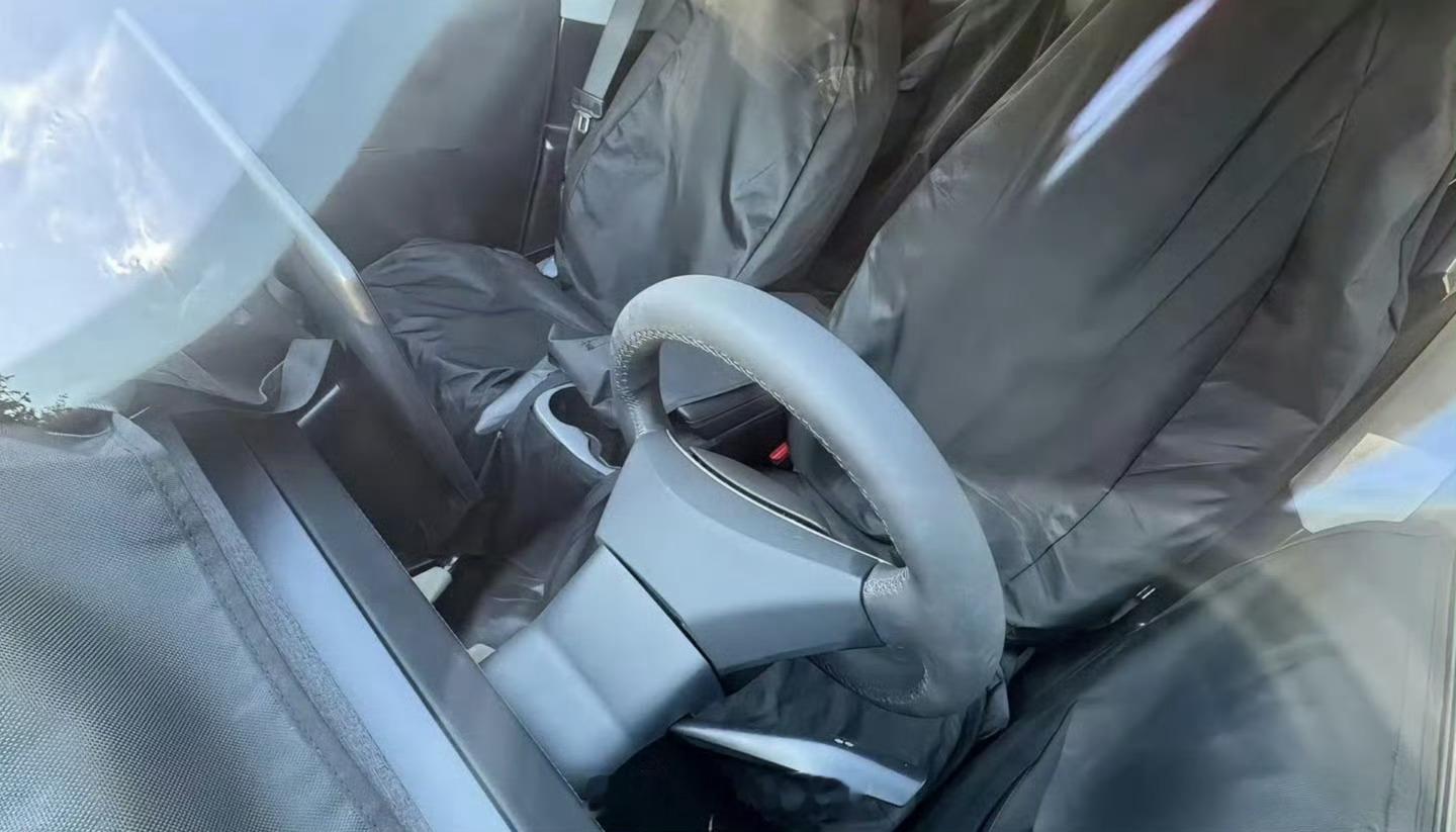 特斯拉廉价版 Model Y 内饰谍照曝光。其取消全景玻璃天幕、贯穿灯带和后排屏